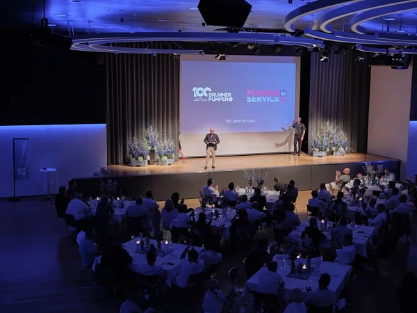 Eventfotografie in Zug: Rede auf der Bühne beim Firmenjubiläum im voll besetzten Saal