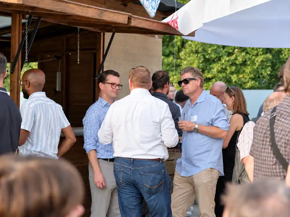 Eventfotografie an einem Firmenanlass in Zug: Gäste im Gespräch beim Empfang auf der Terrasse