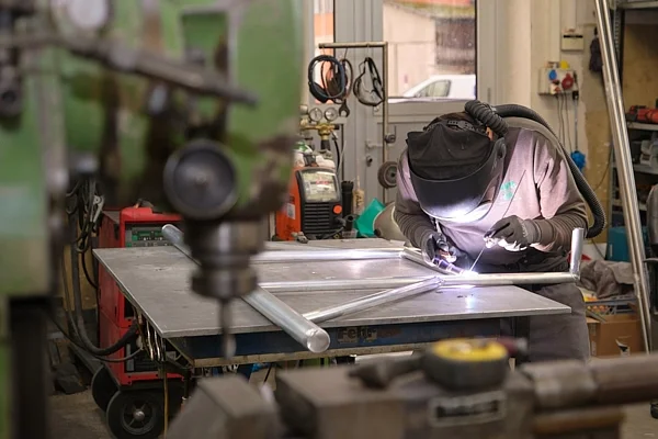 Industriefotografie in Zug: Schweisser bei der Metallbearbeitung in der Werkstatt
